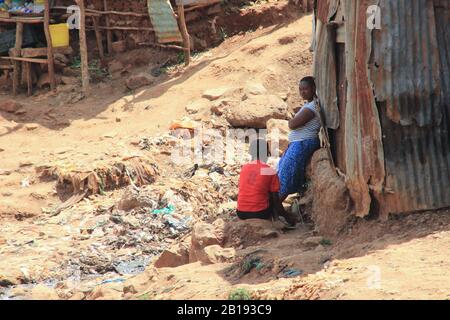Kibera, Nairobi, Kenya - 13 febbraio 2015: Due donne africane nei pressi delle capanne parlano tra i rifiuti Foto Stock