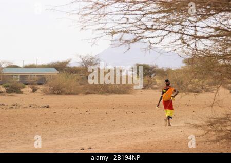 Marsabit, Kenya - 16 gennaio 2015: Donna africana della tribù dei Samburu (legata alla tribù dei Masai) in costume nazionale cammina sulla savana Foto Stock