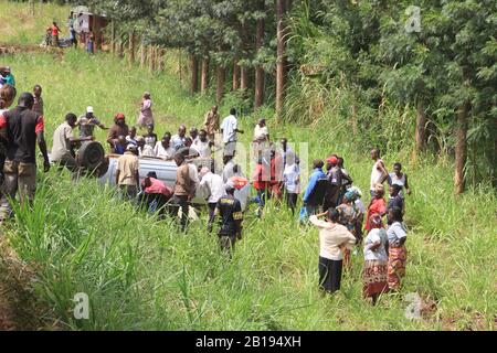 Nairobi, Kenya - 17 febbraio 2015: Incidente sulla strada in Africa. Un'auto capovolta ai margini e una folla di spettatori neri in giro. Foto Stock