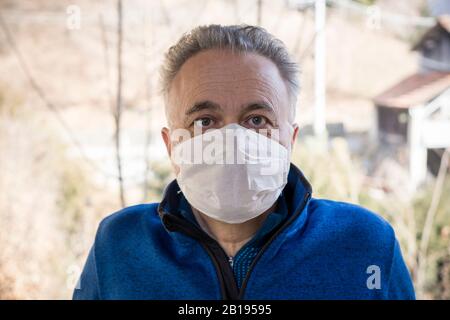 Uomo con maschera medica. Concetto di coronavirus. Protezione respiratoria. Quarantena a casa. Foto Stock