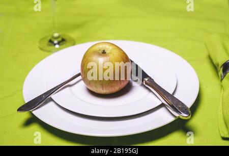 Apple su piastra con coltello e forchetta e vetro su applegreen tovaglia Foto Stock