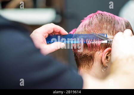 Vista posteriore della donna che ha i suoi capelli tagliati al parrucchiere, closeup. Foto Stock