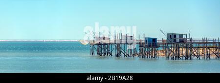 Tipica e antica pesca in legno capanne su palafitte nell'Oceano Atlantico vicino a La Rochelle, Francia Foto Stock