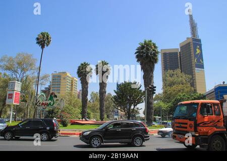 Nairobi, Kenya - 17 gennaio 2015: Centro cittadino di giorno. Edifici, palme e auto sulla strada Foto Stock