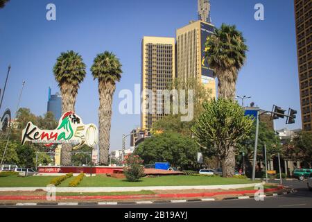 Nairobi, Kenya - 17 gennaio 2015: Centro cittadino di giorno. Edifici, palme e auto sulla strada Foto Stock