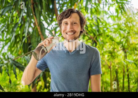 Il giovane usa un irrigatore orale per spazzolare i denti Foto Stock