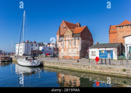 Magazzini e yacht a vela in un canale di Stralsund, Germania Foto Stock