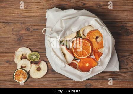 borsa in cotone con patatine fritte su sfondo di legno scuro. vista dall'alto Foto Stock
