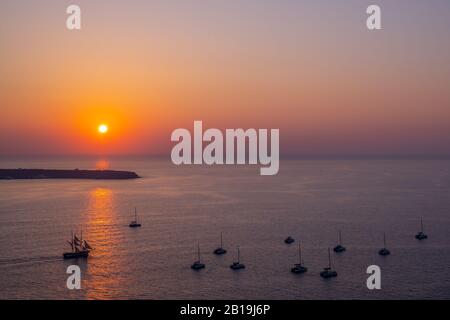 Gli yacht da crociera al tramonto sono salpati e ancorati in un luogo chiaro, permettendo ai turisti a bordo di godersi il tramonto. Foto Stock