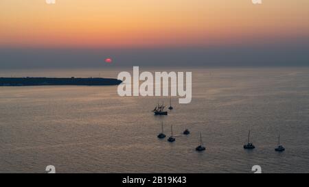 Diversi yacht al tramonto sono ancorati nei mari e permettono ai turisti a bordo di godere il tramonto. Foto Stock