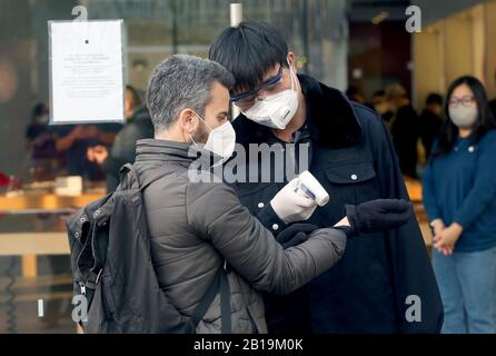Pechino, Cina. 24th Feb, 2020. Una guardia di sicurezza Apple controlla la temperatura delle persone che visitano l'Apple Store a causa della minaccia del mortale coronavirus (Covid-19) che si sta diffondendo a Pechino lunedì 24 febbraio 2020. Il numero dei decessi è di oltre 2.600 persone e ha contagiato più di 79, 00 persone in 28 paesi. Foto di Stephen Shaver/UPI Credit: UPI/Alamy Live News Foto Stock