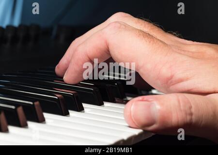 Consegnare un piano o una tastiera del sintetizzatore premendo i tasti o le note per fare musica. Musicista che suona le note su una tastiera del sintetizzatore. Foto Stock