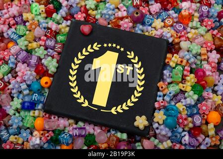 Testo del vincitore del premio 1st sulla confezione regalo con diversi colori di pane per bambini, concetto vincente Foto Stock