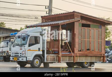 Una piccola casa di legno che viene trasportata su un camion. Foto Stock