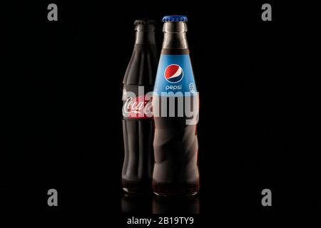 Krasnoyarsk, Russia 23 febbraio 2020: Pepsi e Coca Cola - due bottiglie di soda su sfondo nero, bevande da vicino. Eterna disputa e confronta Foto Stock