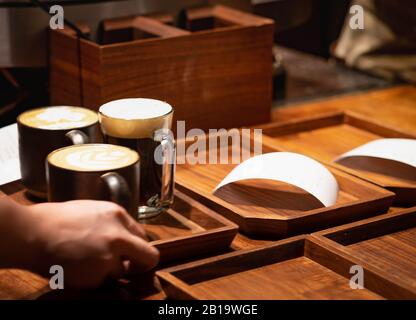 Shanghai, CINA - 11 GENNAIO 2020: Il barista non specifico che serve la bara al cliente presso Il Roastero Starbucks di Shanghai è la più grande al mondo Foto Stock