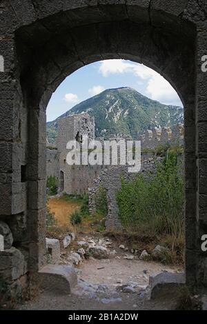 Vista del bailey orientale e crumbling crenellated cortina pareti del Château de Puilaurens, dall'ingresso al tenere, Aude, occitanie, Francia Foto Stock