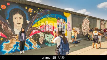 giovane donna asiatica che si posa di fronte al murale nella galleria del lato est Foto Stock