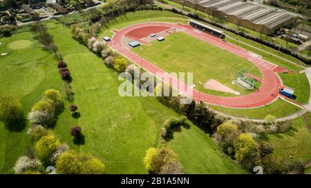 Traccia e campo. Vista aerea degli atleti allenarsi su una pista da corsa del Nord Londra, impostata da un campo da golf in una giornata luminosa e soleggiata. Foto Stock