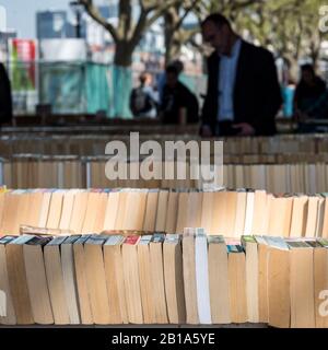 Mercato del libro. Persone che curiosano tra le bancarelle di un mercato all'aperto del libro sulla South Bank del Tamigi, Londra. Foto Stock