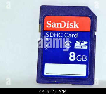 Un primo piano di una scheda di memoria SDHC con marchio Sandisk da 8 GB per l'uso in fotocamere o computer, isolata su sfondo bianco Foto Stock