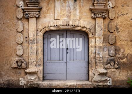 Porta decorata in pietra scolpita con porte dipinte di blu Foto Stock