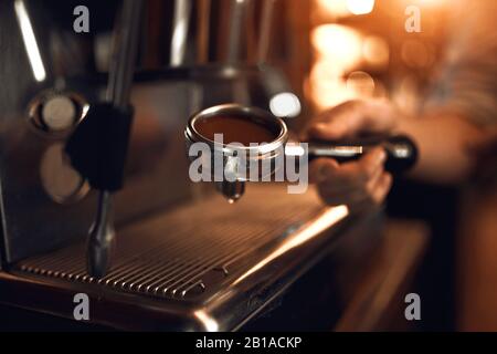 uomo che prepara il caffè per i clienti, primo piano vista laterale foto.preparazione del cappuccino in una caffetteria o ristorante. Foto Stock