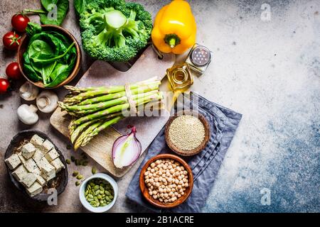 Cucinare cibo sano vegano. Ingredienti per insalata di verdure con tofu e quinoa a tavola. Foto Stock