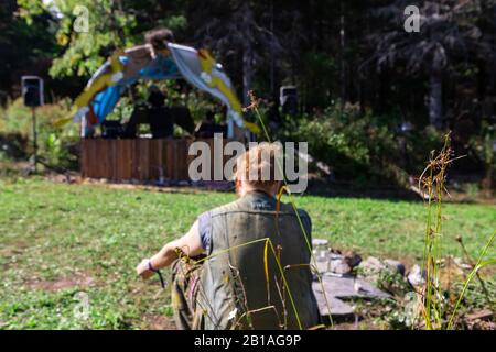Un fuoco selettivo ad ampio angolo di un terreno di festival. Una singola signora è vista sfocata in background, prendendo un po 'di tempo con lo spazio di copia ai lati Foto Stock