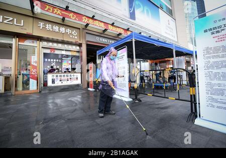 (200224) -- SHENZHEN, 24 febbraio 2020 (Xinhua) -- UN membro del personale disinfetta il terreno nella zona commerciale di Huaqiangbei a Shenzhen, nella provincia del Guangdong della Cina meridionale, 24 febbraio 2020. Huaqiangbei, una rinomata area commerciale a Shenzhen per i mercati dell'elettronica, ha istituito circa 100 tende all'aperto per gli inquilini commerciali per aiutarli a riprendere le imprese con misure di prevenzione e controllo epidemico. (Xinhua/Mao Siqian) Foto Stock