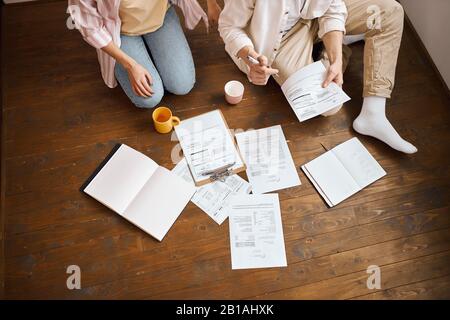 giovani che lavorano con carta, documenti, foto ritagliate. famiglia in via di sviluppo business. coppia che gestisce il loro tasso Foto Stock
