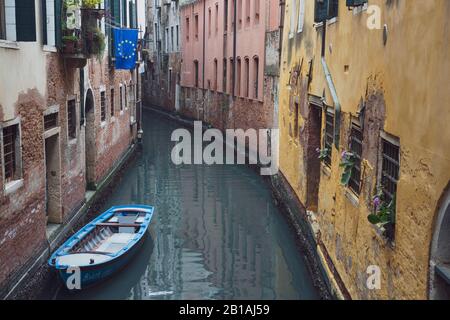 Una bandiera dell'UE vola da un edificio accanto a un canale senza persone a Venezia, Italia Foto Stock