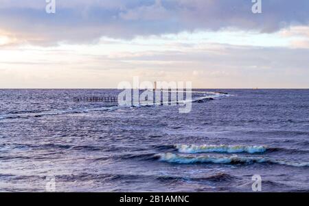 Calmo sfondo di mare con faro e piccole onde Foto Stock