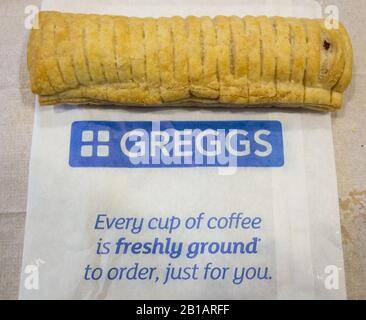 Un rotolo di salsiccia per vegani Greggs su un tavolo in una caffetteria Gregg Foto Stock