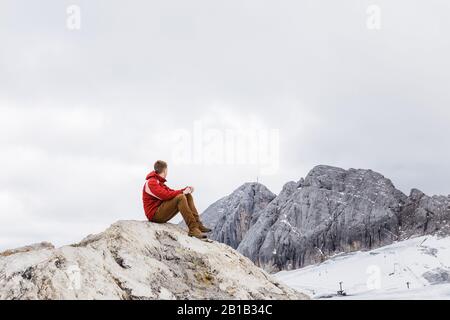 Giovane uomo millenario gode della vista sulle Alpi che si eran sul ghiacciaio Foto Stock