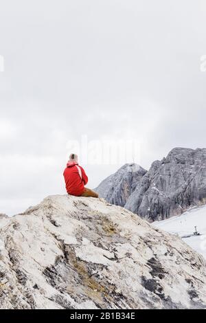 Giovane uomo millenario gode della vista sulle Alpi che si eran sul ghiacciaio Foto Stock