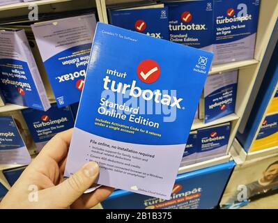 Montreal, Canada - 10 febbraio 2020: Software TurboTax Standard online Edition su CD e scatola di licenza in mano. TurboTax è un preparati americano di imposta Foto Stock