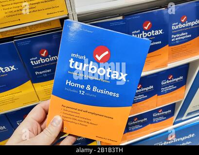 Montreal, Canada - 10 febbraio 2020: Software TurboTax Home e Business su CD e scatola di licenza in mano. TurboTax è un'amministrazione fiscale americana Foto Stock