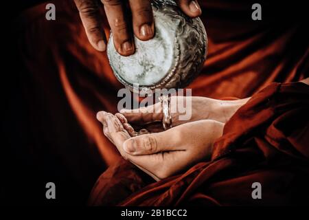 Mani vicine. Acqua profumata spruzzata sulla mano del monaco. Acqua versante tradizionale in Thai nuovo anno. Bellezza tradizionale di Thai. La tradizionale Thai Foto Stock