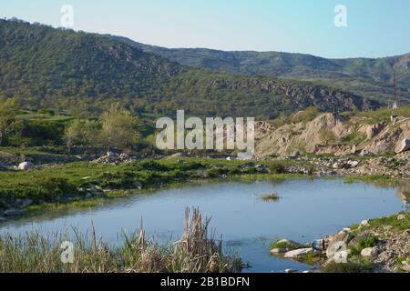Lago di Xizi . Incredibile paesaggio di lago con acqua cristallina verde e cielo blu. Vista panoramica sul bellissimo paesaggio montano. Montagne verdi Foto Stock