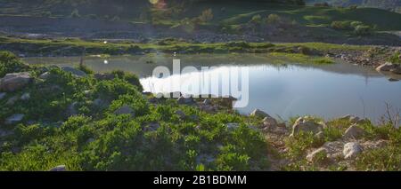Lago di Xizi . Incredibile paesaggio di lago con acqua cristallina verde e cielo blu. Vista panoramica sul bellissimo paesaggio montano. Montagne verdi Foto Stock