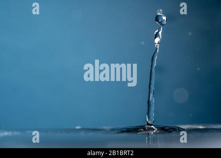 Acqua dolce e limpida che scorre su sfondo blu Foto Stock