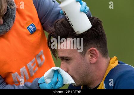 Un giocatore di calcio del randello di rugby dilettante che riceve le cure mediche. Foto Stock