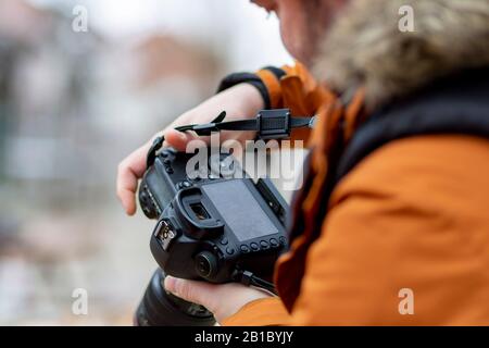 Il fotografo e la sua macchina che controlla la fotografia scattata Foto Stock