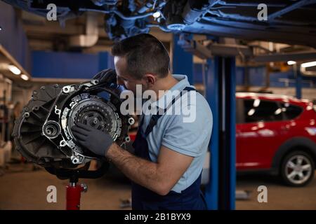 Girovita ritratto di meccanica muscolare auto ispezione cambio in officina di riparazione automatica, copia spazio Foto Stock