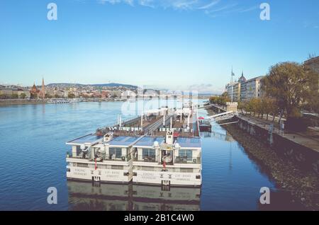 Budapest, Ungheria - 6 novembre 2019: Enorme nave da crociera turistica sul Danubio nella capitale ungherese. Centro storico in fondo. Foto orizzontale con filtro. Foto Stock