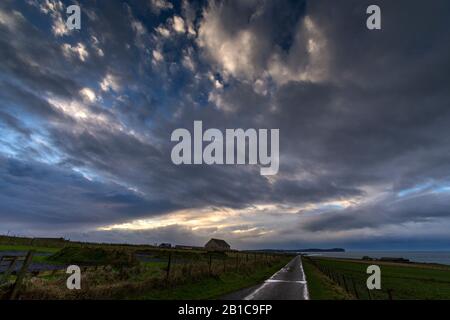 Nuvole drammatiche su Dunnet Head, dalla stretta strada costiera, East Mey, Caithness, Scozia, Regno Unito Foto Stock