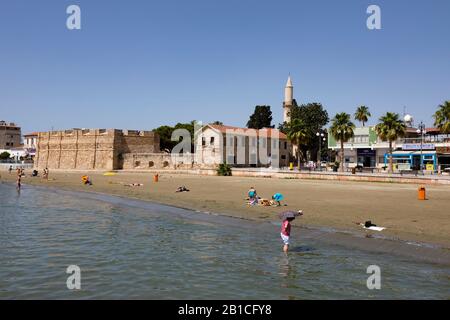 Turisti sulla spiaggia vicino al forte, Finikoudes, Larnaca. Cipro. 2019 Foto Stock