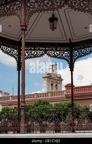 Cicogne bianche nei loro nidi sulla punta della cappella di San Ildefonso della città di Alcala de Henares visto dalla bandstand di piazza cervantes Foto Stock