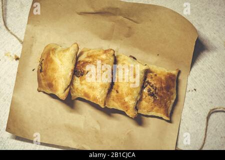 Samsa consegna nella carta astuta. Samsa - un saporito pasticcere di carne nella cucina dell'Asia Centrale Foto Stock